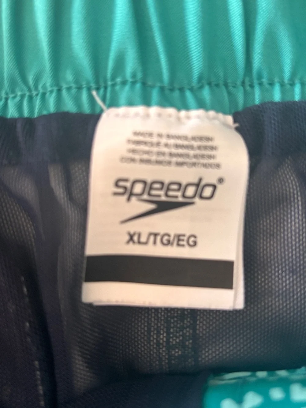 Speedo men's swim shorts with white floral pattern on teal background, size XL